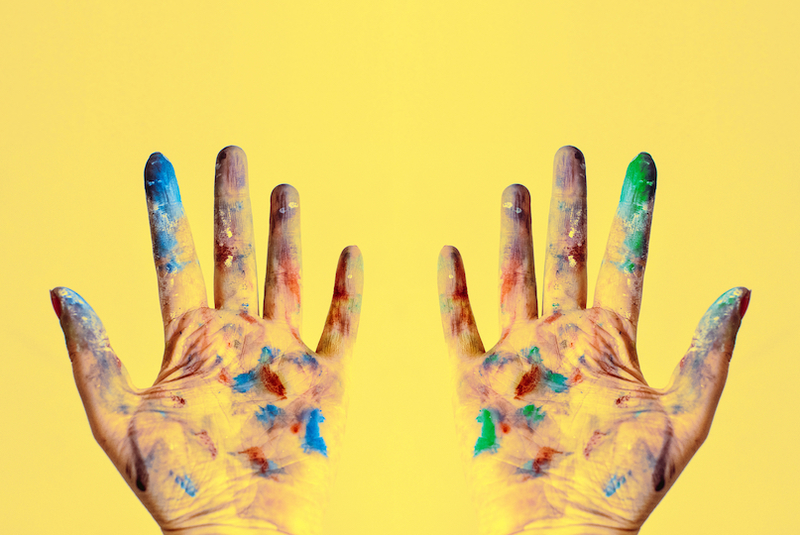 Canva both hands stained with paints